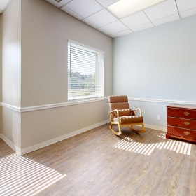 Settle into comfort at The Auberge at Aspen Park a room with a chair and a rug